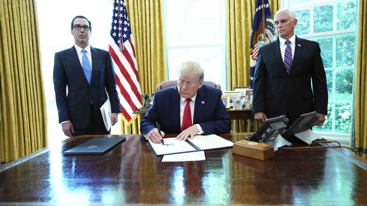 President Trump signs sanctions on Iran's supreme leader as Treasury Secretary Steven T. Mnuchin, left, and Vice President Mike Pence look on at the White House on June 24, 2019.
