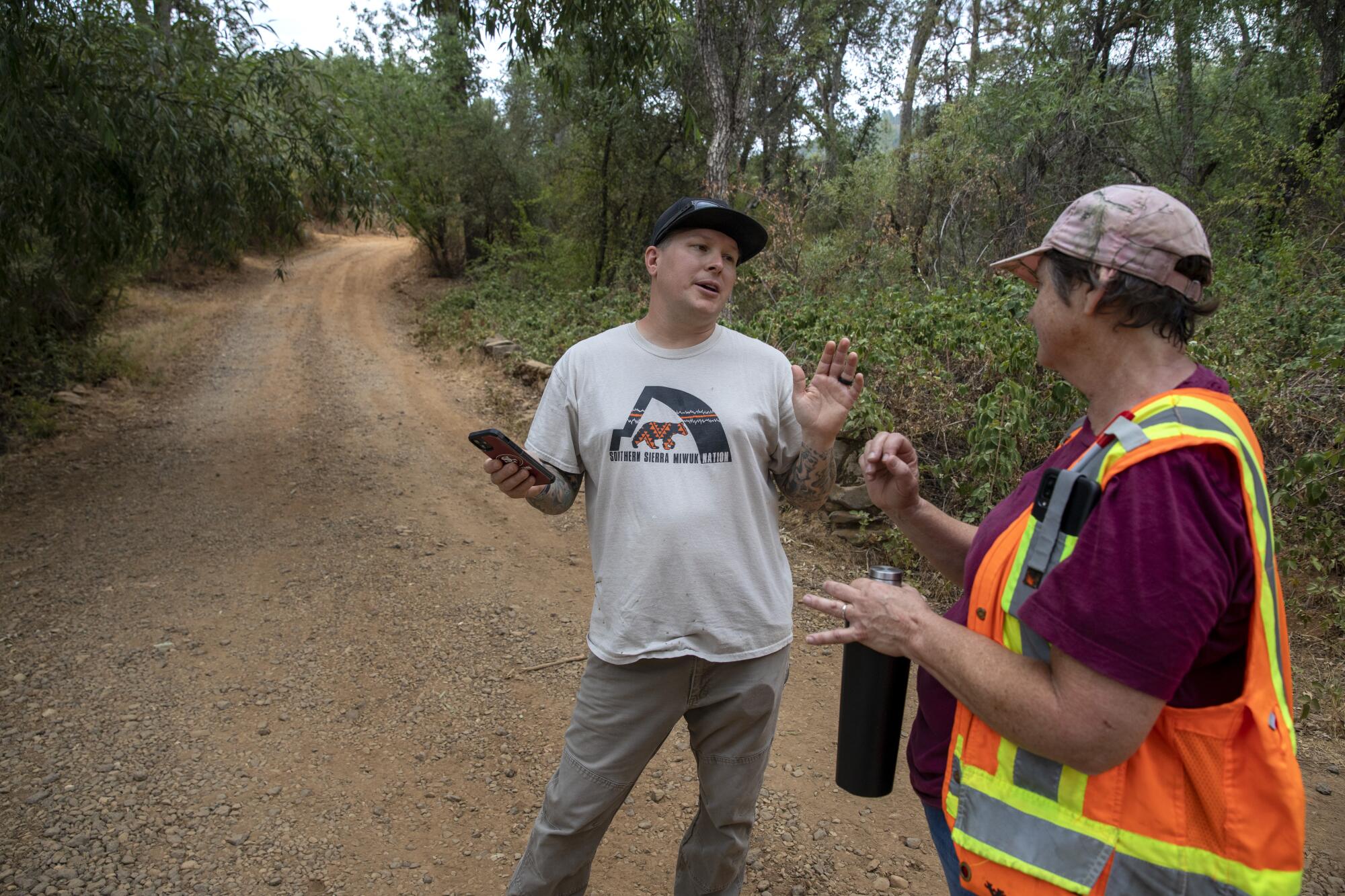 Waylon Coats talks with archaeologist Charlane Gross on a dirt road.