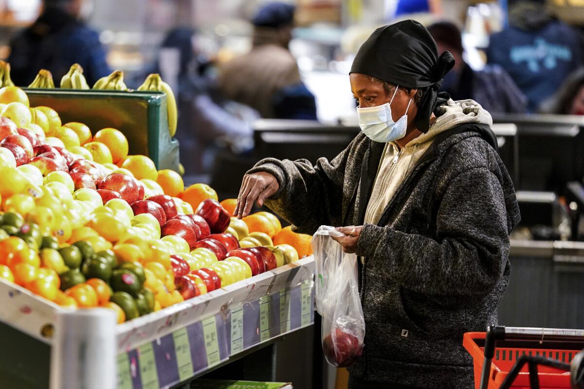 A shopper selects fruit at a market