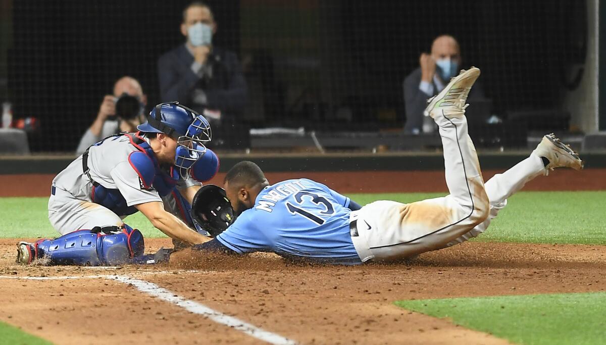 Austin Barnes tags out Manuel Margot at home plate.