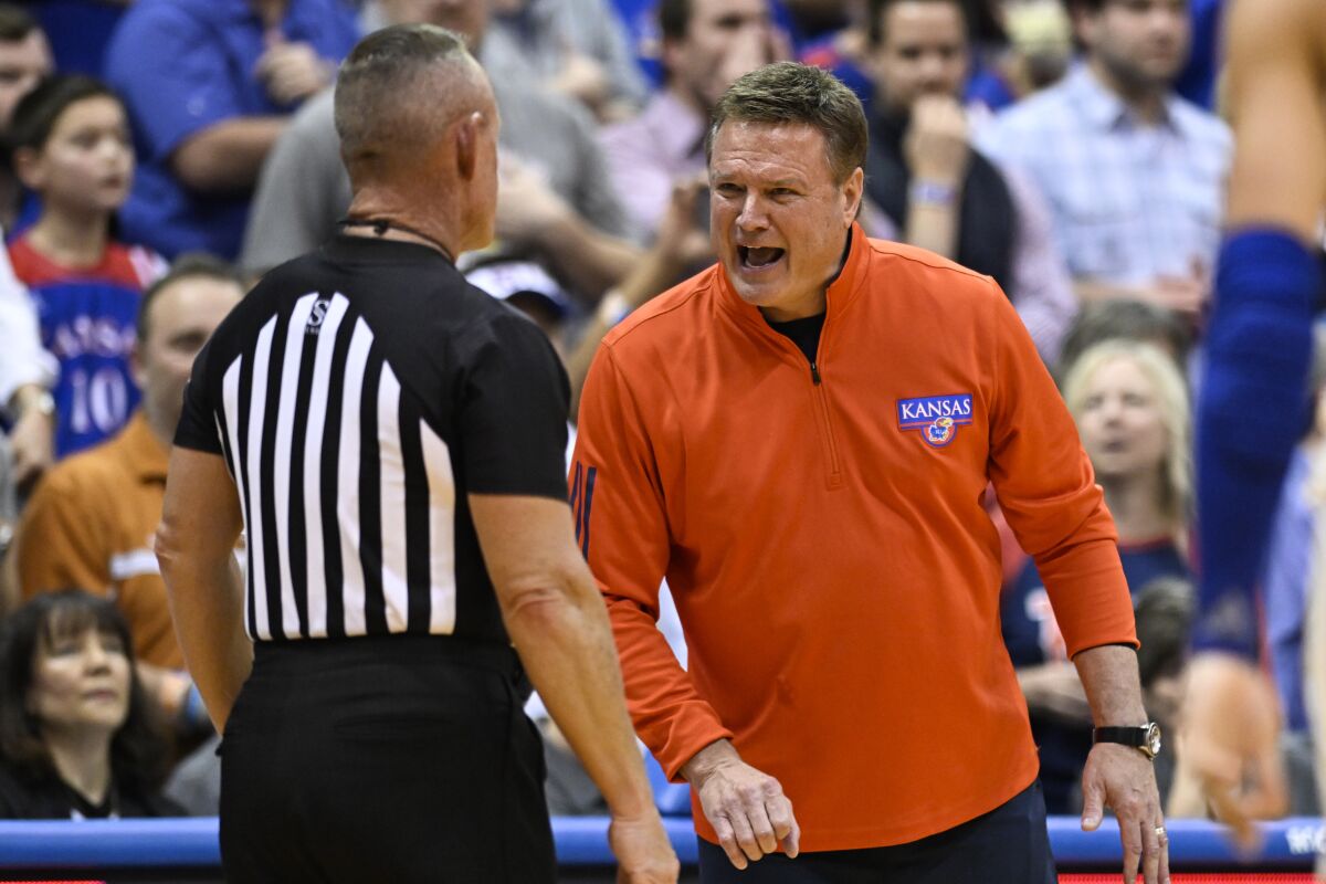 Kansas head coach Bill Self, right, argues a call with an official during the second half of an NCAA college basketball game against Texas in Lawrence, Kan., Saturday, March 5, 2022. (AP Photo/Reed Hoffmann)