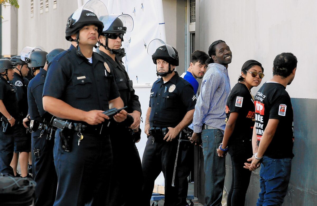 LAPD officers detain about a dozen anti-police brutality protestors in downtown Los Angeles