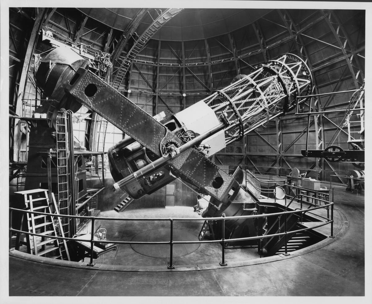 The Hooker 100-inch reflecting telescope, side view with tube 40 degrees from horizontal. Edwin Hubble's chair, on an elevating platform, is visible at left.