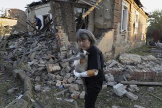 Injured Ludmila Ivanchuk, 61, holds her cat "Vasia" in front of her house which was damaged by a Russian rocket attack in Kostiantynivka, Donetsk region, Ukraine, Wednesday, September 27, 2023. (AP Photo/Alex Babenko)