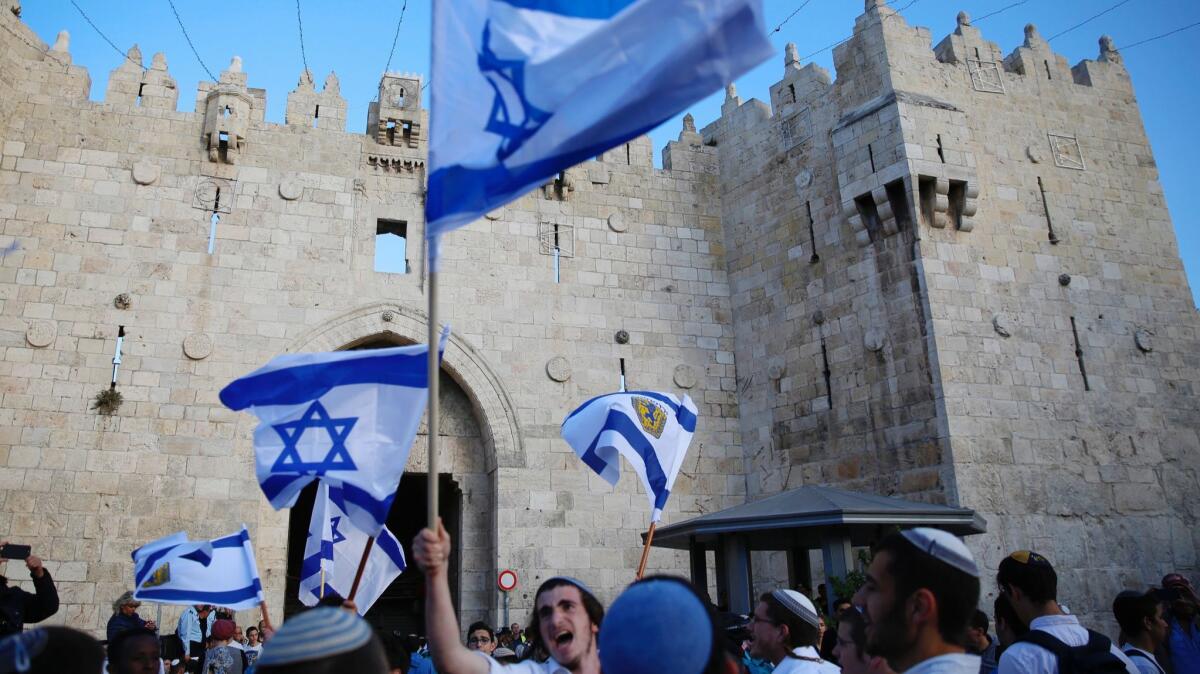 Israelis wave national flags outside the Old City's Damascus Gate in Jerusalem on May 13.