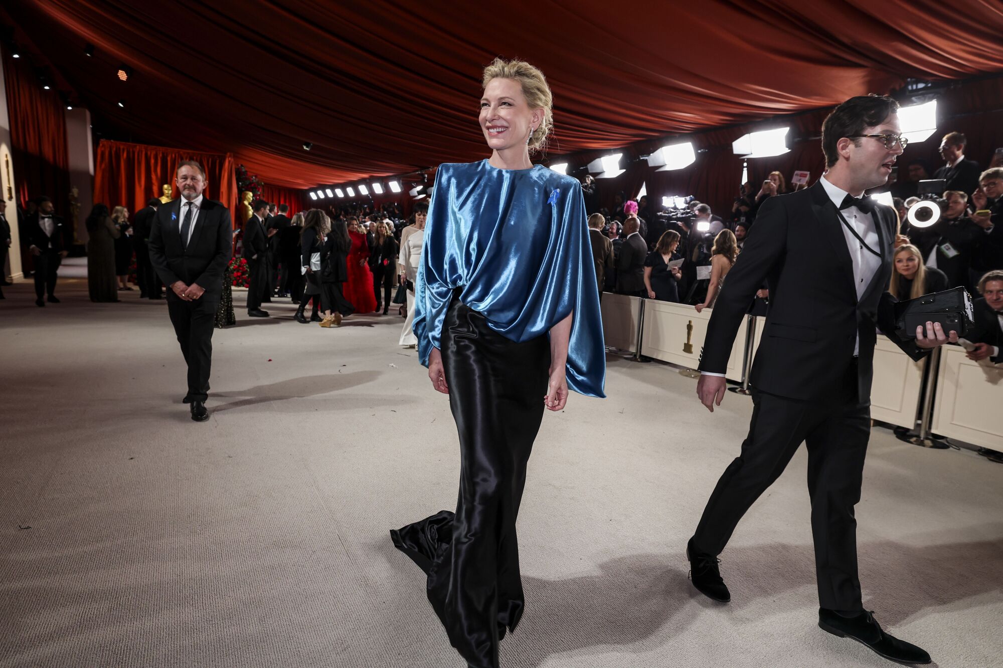 Cate Blanchett in a black skirt and poufy, della robbia blue top.