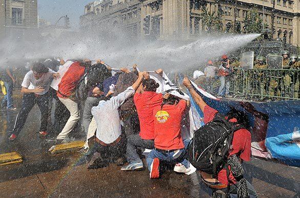 Riot police blast Chilean workers with water cannons as they demonstrate along Alameda Avenue in downtown Santiago. Thousands of workers, teachers and students demonstrated against mass layoffs that have resulted from the global economic crisis.