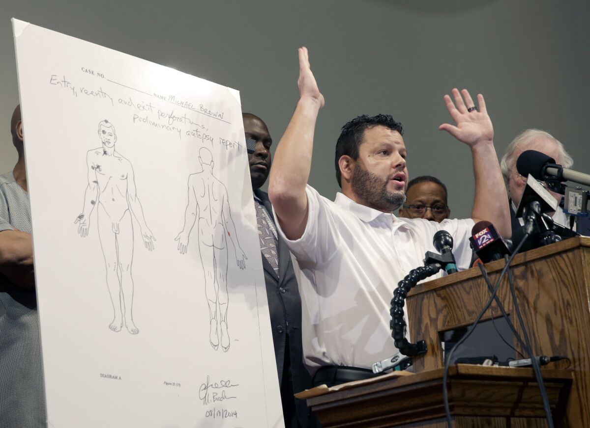 FILE - Shawn Parcells speaks during a news conference in St. Louis County, Mo., Aug. 18, 2014. Parcells, a Kansas man accused of fooling people into paying for autopsies that his company never performed plans to plead guilty to federal charges, according to court records. Shawn Parcells, of Leawood, on Tuesday, Feb. 1, 2022, filed a notice of intent to change his plea in federal court in Topeka. A change of plea hearing is scheduled for March 3. (AP Photo/Jeff Roberson File)