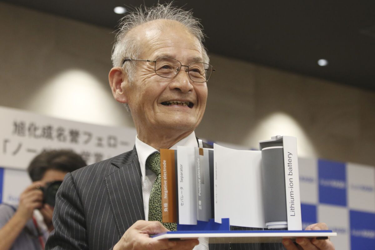 Akira Yoshino poses a photo with a model of a lithium-ion battery during a news conference in Tokyo on Oct. 9, 2019, after winning the Nobel Prize in chemistry.