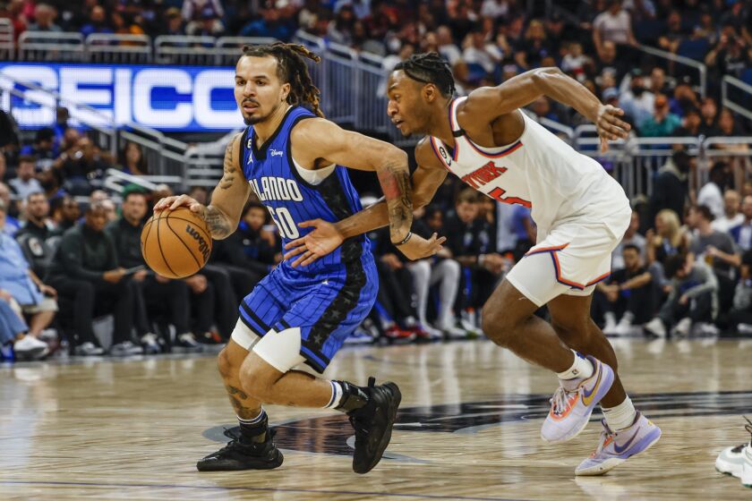 Orlando Magic guard Cole Anthony (50) dribbles past New York Knicks guard Immanuel Quickley (5) during the second half of an NBA basketball game, Thursday, March 23, 2023, in Orlando, Fla. (AP Photo/Kevin Kolczynski)
