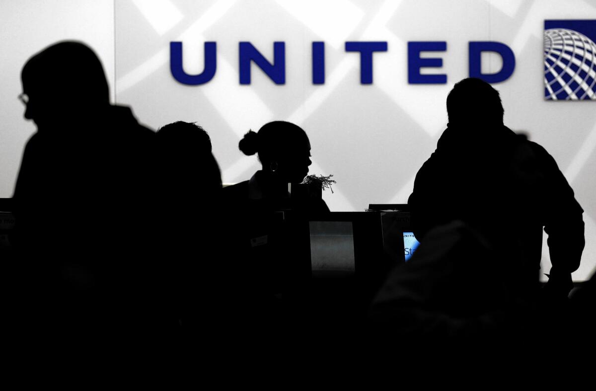 Travelers check in at the United Airlines ticket counter at O'Hare International Airport in Chicago. Major airlines' frequent-flier programs have switched from not only rewarding distances traveled but also money spent.