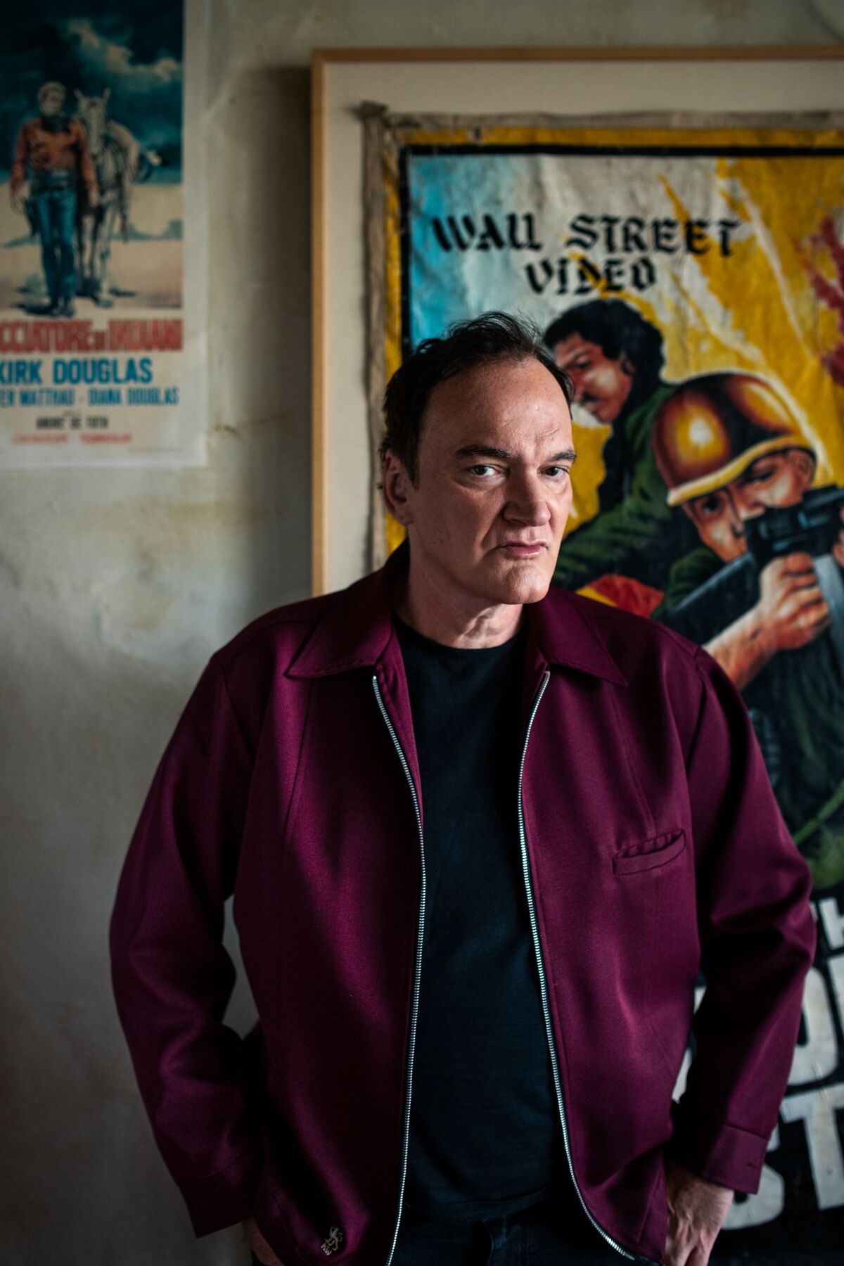 Quentin Tarantino in front of one of his vintage movie posters at his home