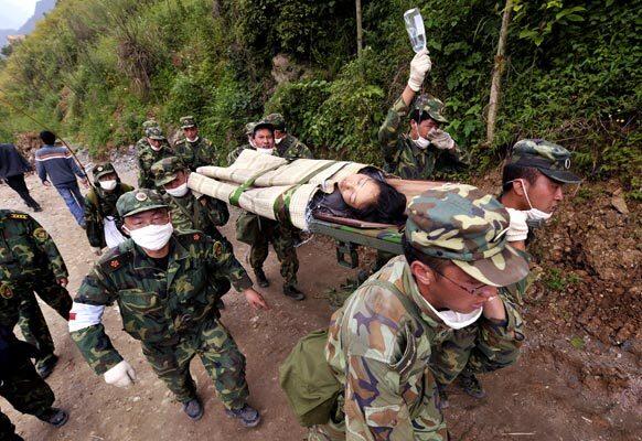 Rescuers carry a quake victim from the town of Beichuan. More than 100,000 were injured in Sichuan province, where the quake was centered, the vice governor told reporters.