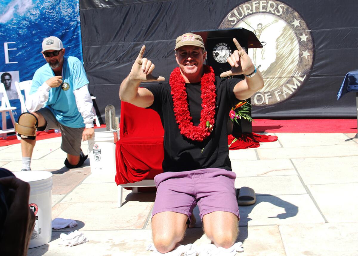 Surfers' Hall of Fame inductee Jamie O'Brien signs "hang loose" during Friday's ceremony.