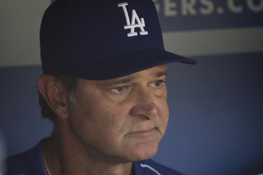 Dodgers Manager Don Mattingly talks to the media in the dugout at Dodger Stadium on Oct. 6.