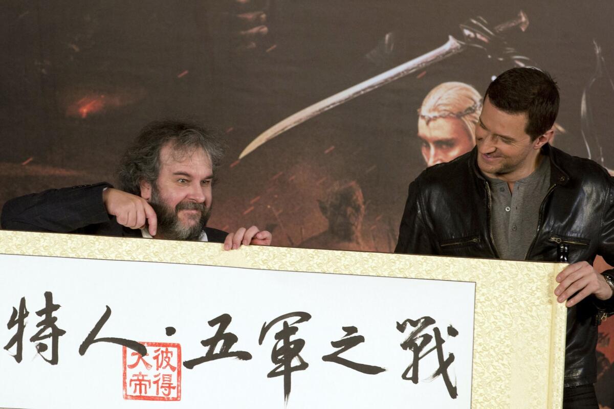 Director Peter Jackson, left, points at a red stamp with the words "Peter the Great" in Chinese calligraphy with the words for "The Hobbit: The Battle of the Five Armies" as actor Richard Armitage looks on during a news conference in Beijing on Jan. 19.