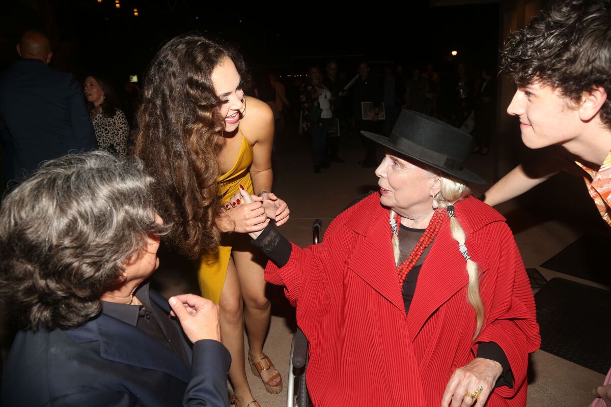 Singer Joni Mitchell, wearing red, greets actress Solea Pfeiffer, along with playwright Cameron Crowe, left, and actor Casey Likes, 17, at the "Almost Famous" world premiere at The Old Globe on Friday, Sept. 27.
