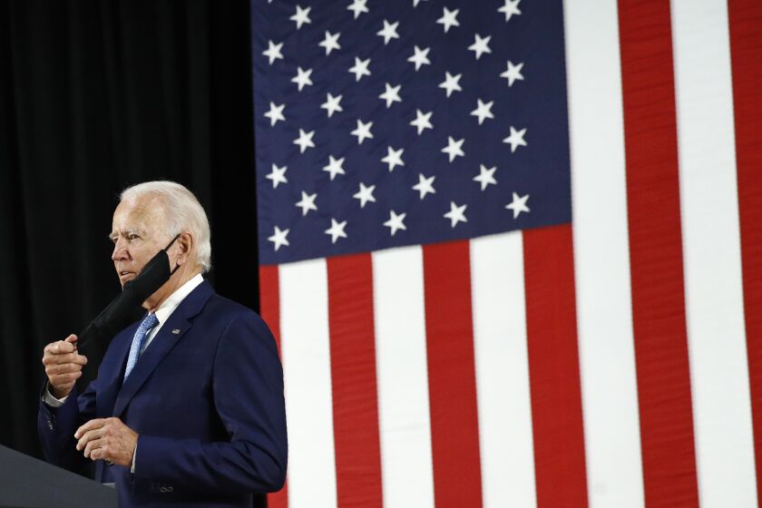 Democratic presidential candidate, former Vice President Joe Biden removes a face mask to protect against the spread of the new coronavirus as he arrives to speak at Alexis Dupont High School in Wilmington, Del., Tuesday, June 30, 2020. (AP Photo/Patrick Semansky)