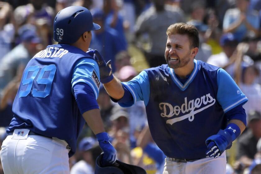 Los Angeles Dodgers' Hyun-Jin Ryu, left, of South Korea, and Brian Dozier celebrate after they scored on a double by Justin Turner during the fifth inning of a baseball game against the San Diego Padres, Sunday, Aug. 26, 2018, in Los Angeles. (AP Photo/Mark J. Terrill)