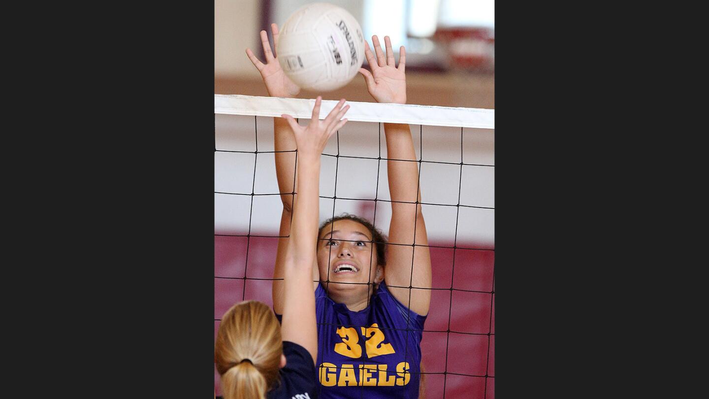 Holy Family's Cyndel Lopez reaches to block St. Monica Academy's Elizabeth McCall in a nonleague girls' volleyball match at Maple Park Community Center in Glendale on Tuesday, Sept. 12, 2017. Holy Family won the match 3-0.