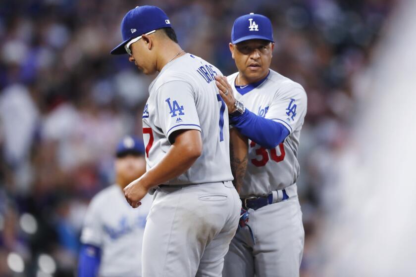 Los Angeles Dodgers manager Dave Roberts, right, pulls starting pitcher Julio Urias from the mound in the third inning of a baseball game against the Colorado Rockies Tuesday, July 30, 2019, in Denver. (AP Photo/David Zalubowski)