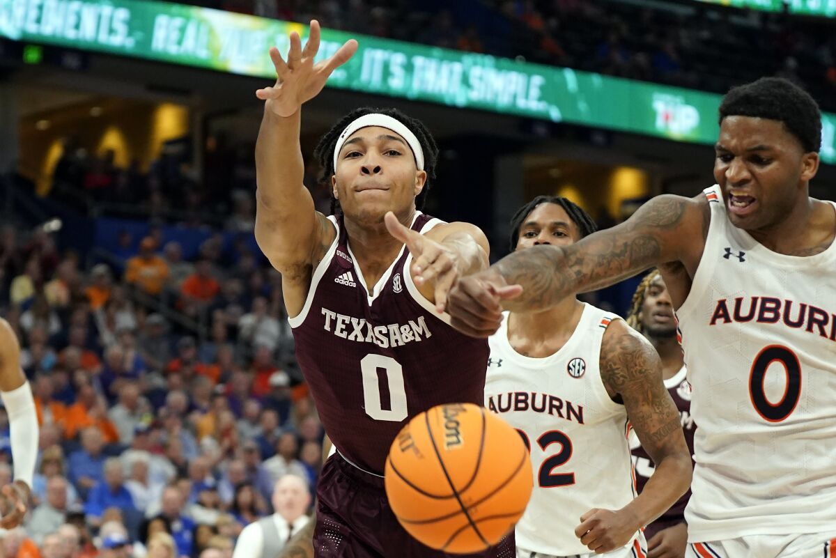 Texas A&M guard Aaron Cash, left, and Auburn guard K.D. Johnson go for the ball during the second half of an NCAA men's college basketball Southeastern Conference tournament game Friday, March 11, 2022, in Tampa, Fla. (AP Photo/Chris O'Meara)