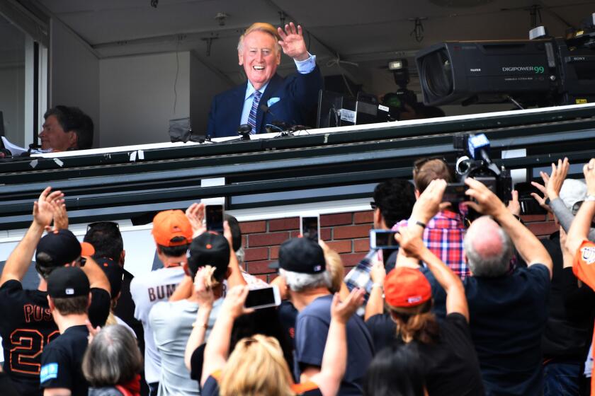 Dodgers broadcast announcer Vin Scully waves to the crowd while being honored at AT&T Park.