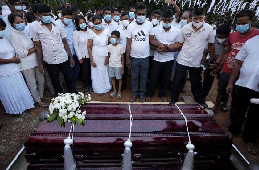 Family members of Sri Lankan factory manager Priyantha Kumara who was lynched by a Muslim mob in Pakistan for alleged blasphemy gather around the grave during his burial in Colombo, Sri Lanka, Wednesday, Dec. 8, 2021. (AP Photo/Eranga Jayawardena)