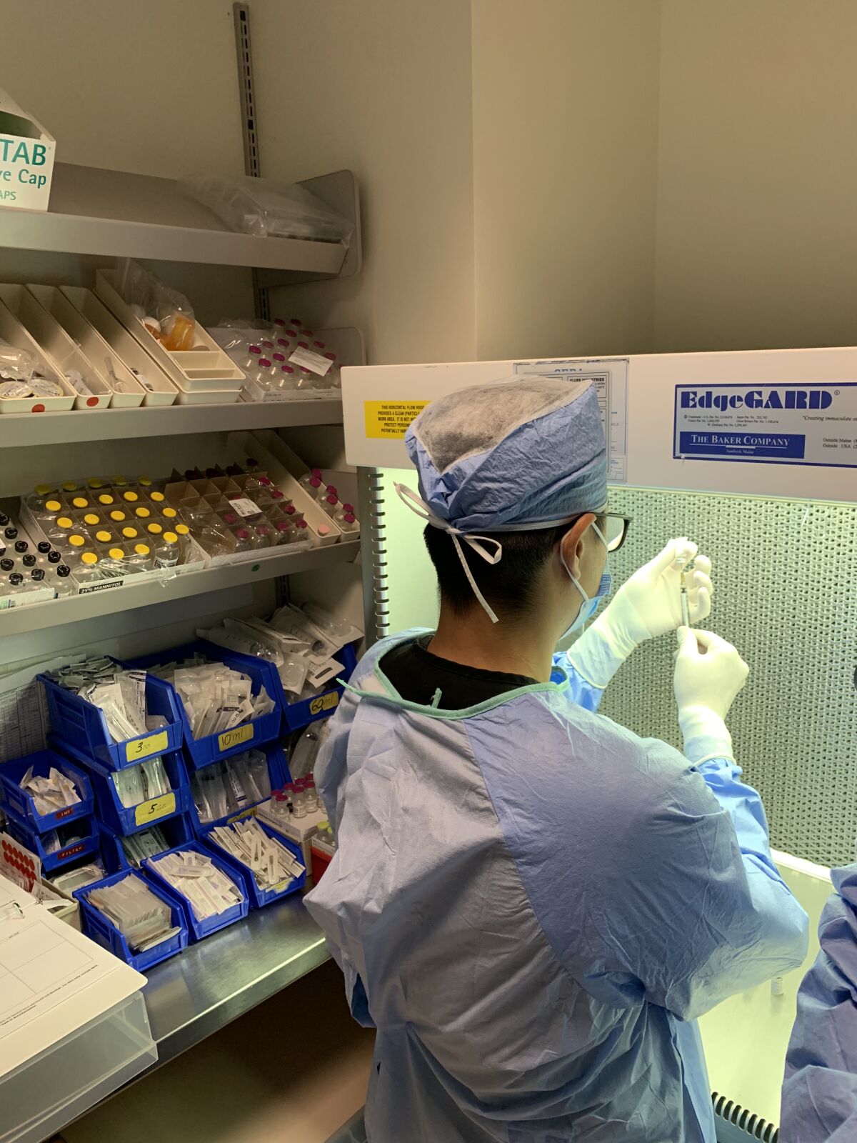 A pharmacy technician measures out the dosage.