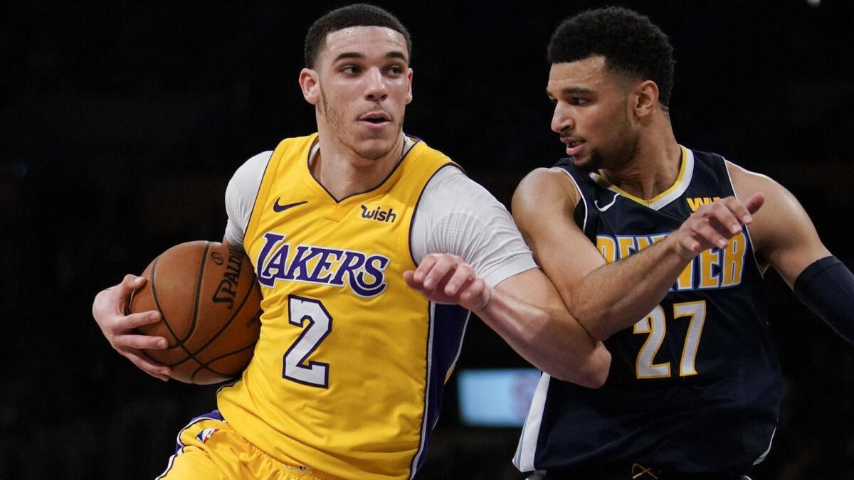Lakers guard Lonzo Ball tries to power his way to the basket against Nuggets guard Jamal Murray during a game last season.