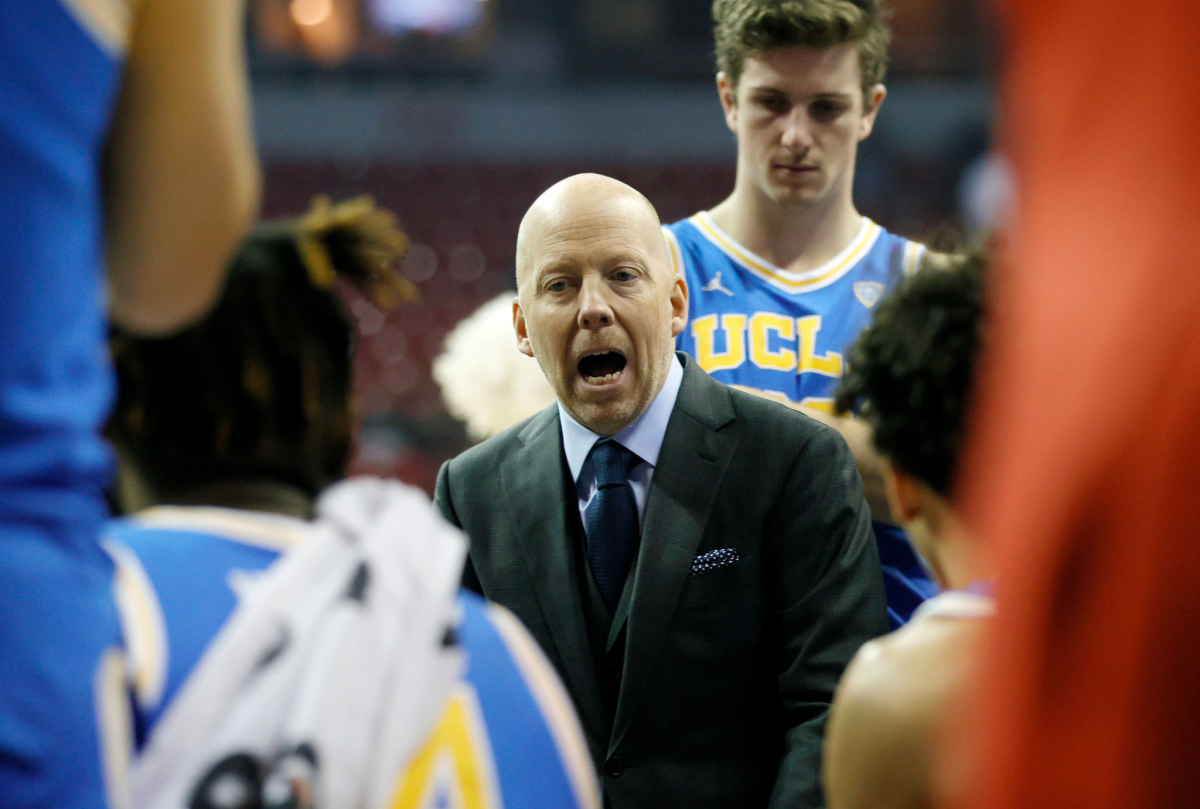UCLA coach Mick Cronin talks to his players during a timeout