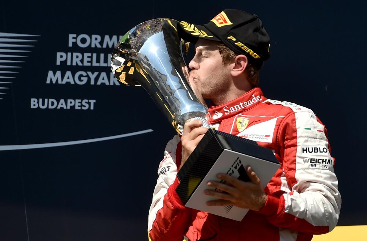 TOPSHOTS Ferrari's German driver Sebastian Vettel kisses the trophy as he celebrates on the podium winning the Hungarian Formula One Grand Prix at the Hungaroring circuit near Budapest on July 26, 2015. AFP PHOTO / ANDREJ ISAKOVICANDREJ ISAKOVIC/AFP/Getty Images ** OUTS - ELSENT, FPG - OUTS * NM, PH, VA if sourced by CT, LA or MoD **