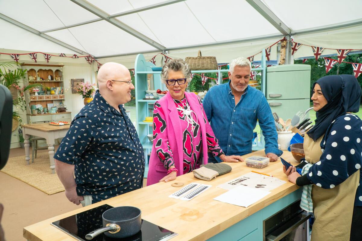 Contestant Sura, right, with host Matt Lucas, from left, and judges Prue Leith and Paul Hollywood.