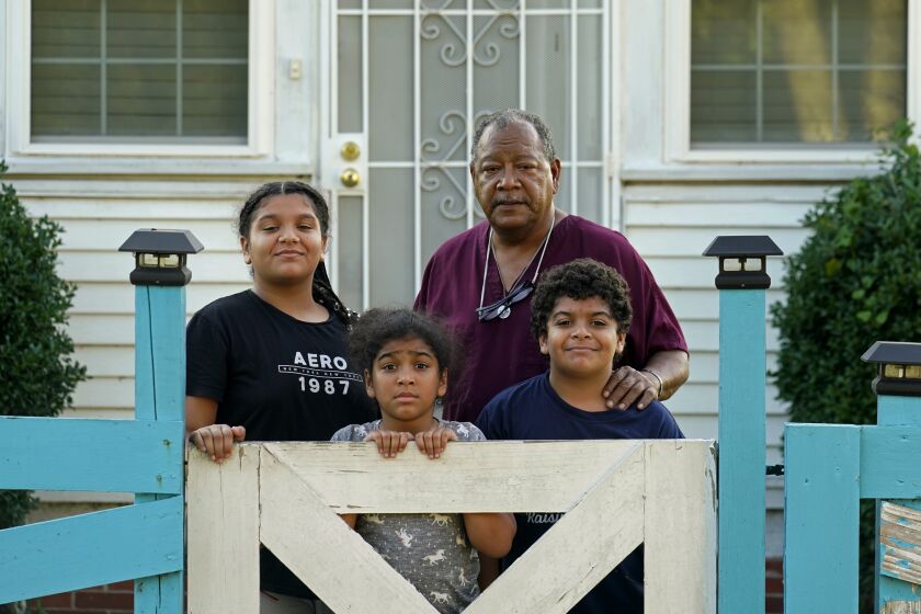 Angelo Bernard, who lives near the Denka Performance Elastomer Plant, poses with his grandchildren who are visiting him for the weekend, at his home in Reserve, La., Friday, Sept. 23, 2022. From left are Korinne Bernard, 11, Karmen Bernard, 9, and Anthony Bernard, 10, who used to attend Fifth Ward Elementary until Hurricane Ida forced them to move. "I feel for the kids that have to go to school that close to the plant," Angelo Bernard said. (AP Photo/Gerald Herbert)