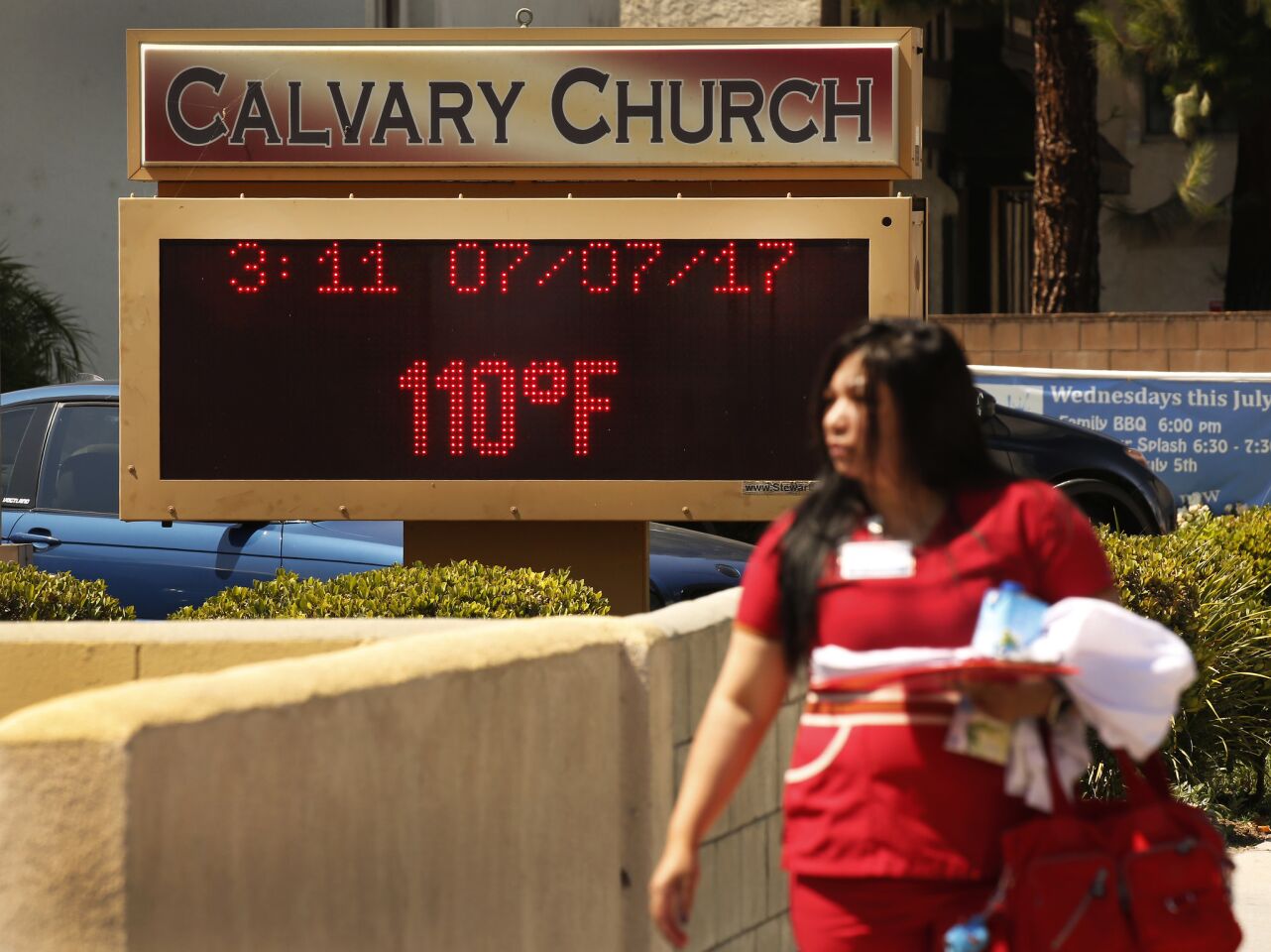 People brave record 110-degree temperature Friday while walking to work in West Hills in the San Fernando Valley.