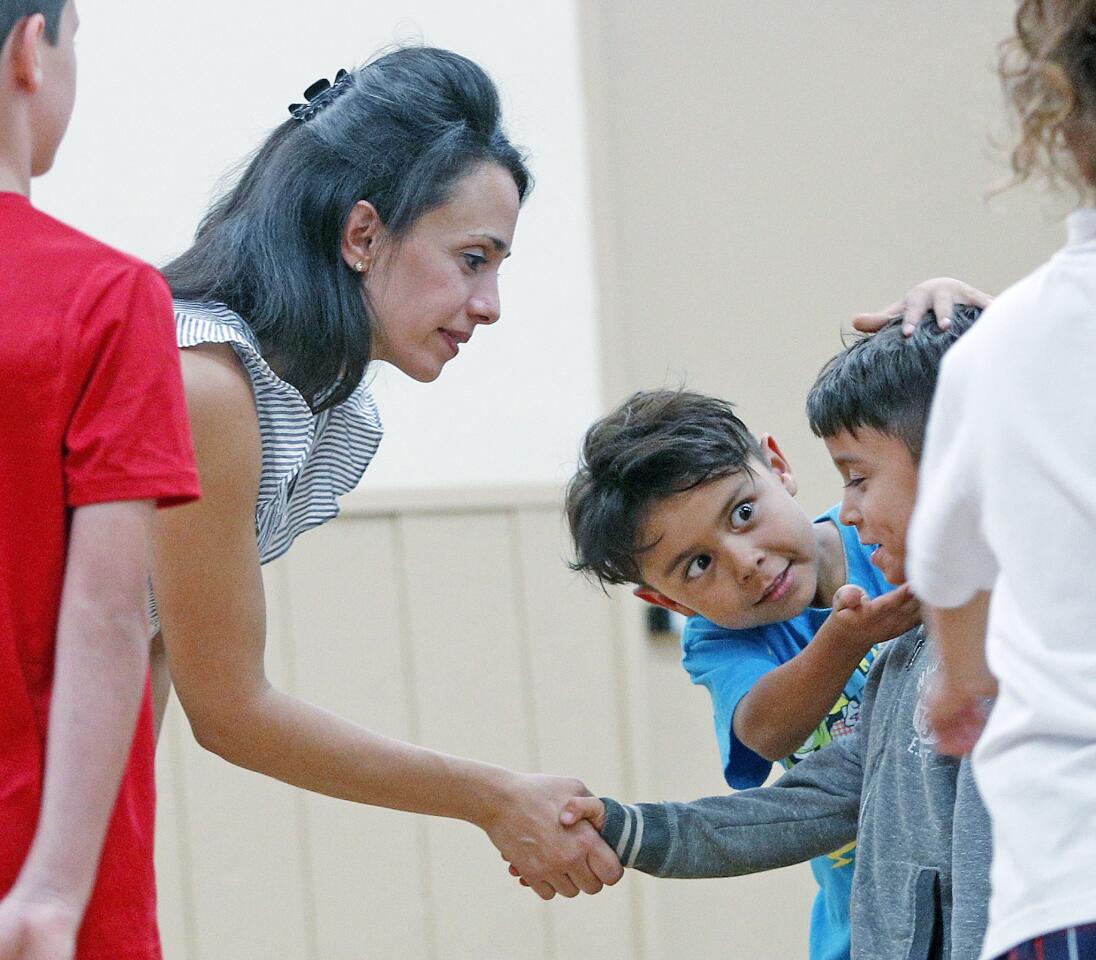 As Instructor Dianeh O'Farrill shakes the hand of Emilio Sandquist, 6, of La Canada Flintridge, his brother Leo, 7, tries to correct his head so he can look his teacher in the eye at a manners class, taught by Socially Confident Kids, at the Community Center of La Canada Flintridge on Tuesday, September 25, 2018. The young children learned about smiling, shaking hands, eye contact, and table etiquette.