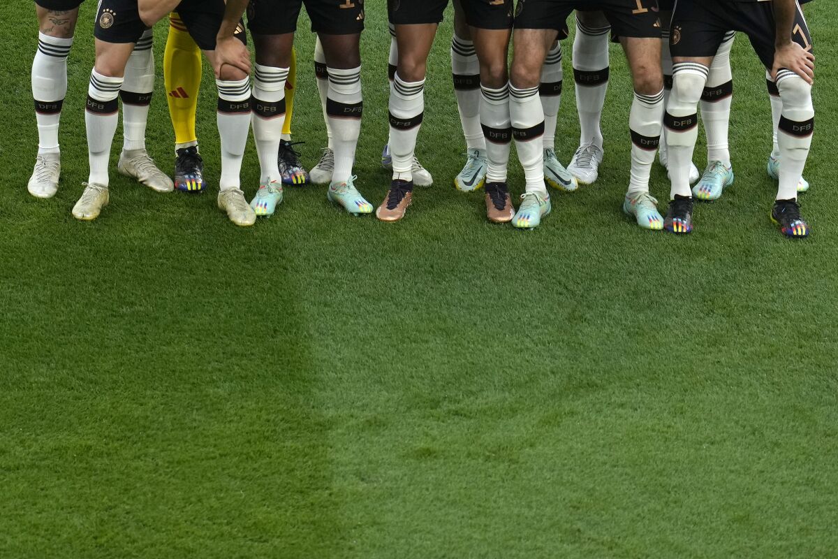 Many of Germany's soccer players have rainbow colors on their boots as they pose for a team group photo.