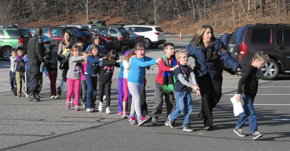 Children are led by police from Sandy Hook Elementary School in Newtown, Conn., after the shooting on Dec. 14, 2012, in which 20 first-graders and six educators were killed.