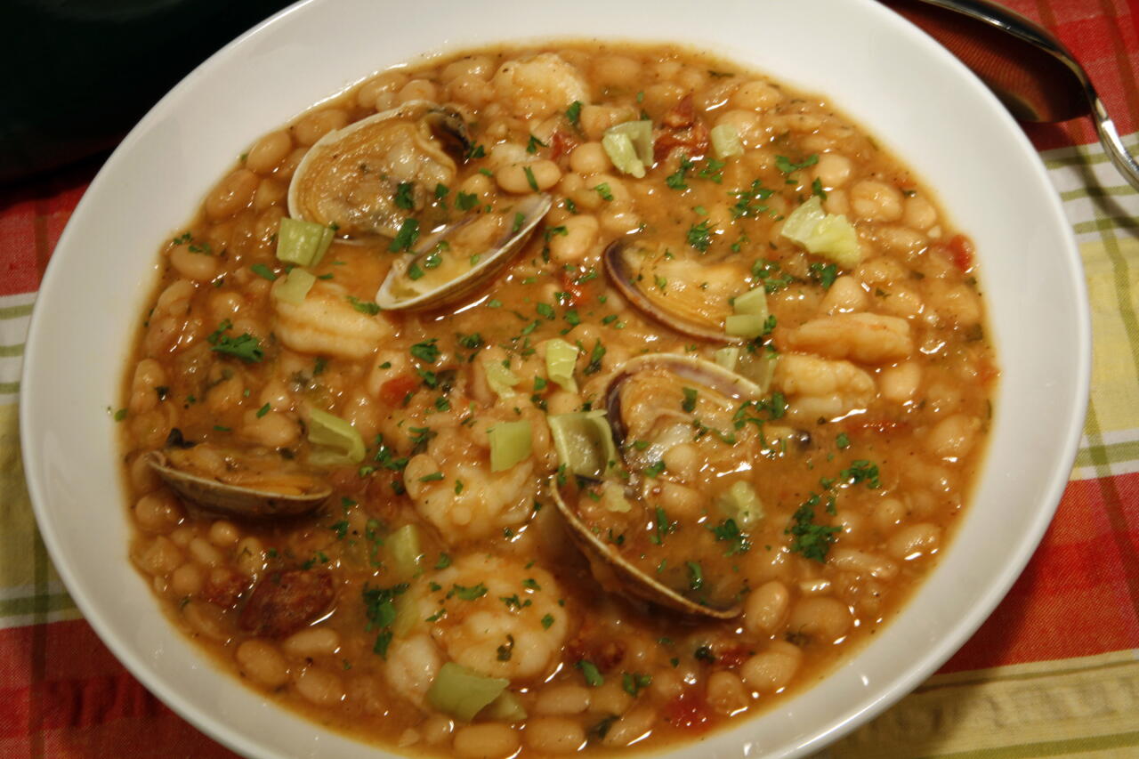 White beans, chorizo, clams and shrimp in a bowl.