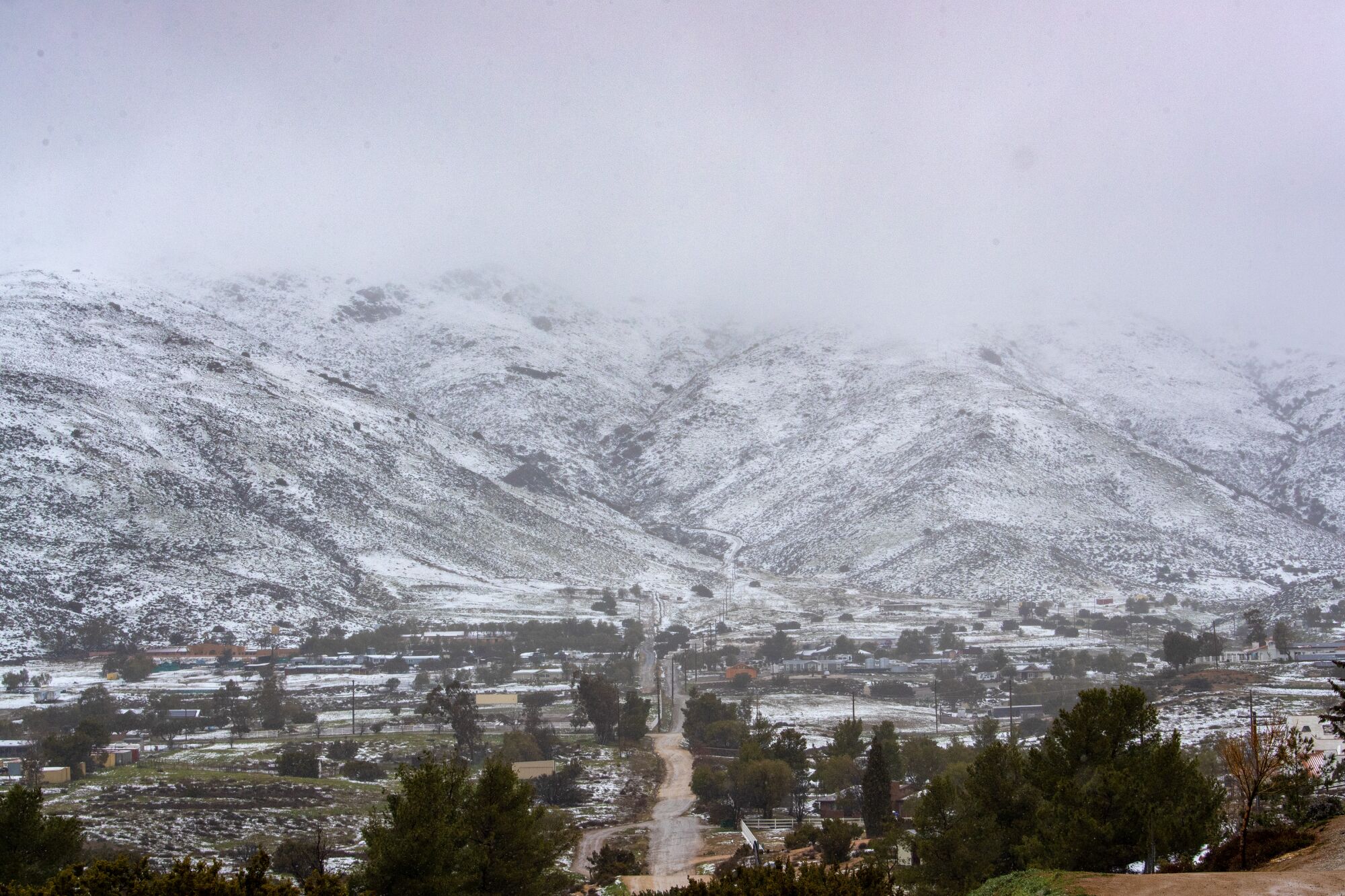 Low clouds cloak the snow-covered mountains above Acton, near the Antelope Valley, on Friday.