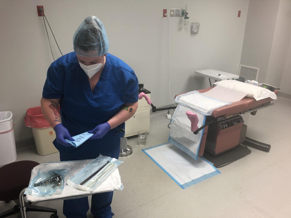 A healthcare worker prepares a room at the clinic in Wichita, Kan.