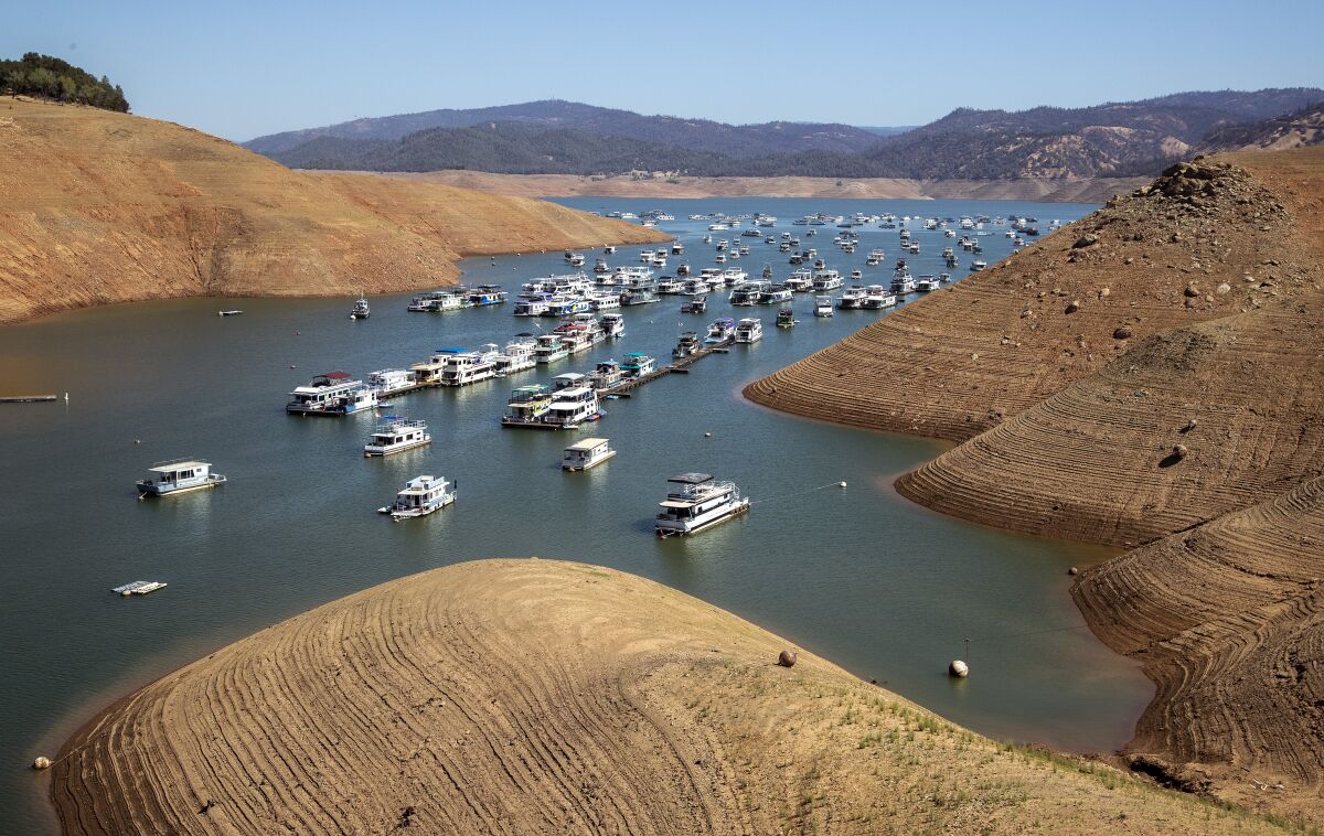 Dozens of houseboats float on a receding lake