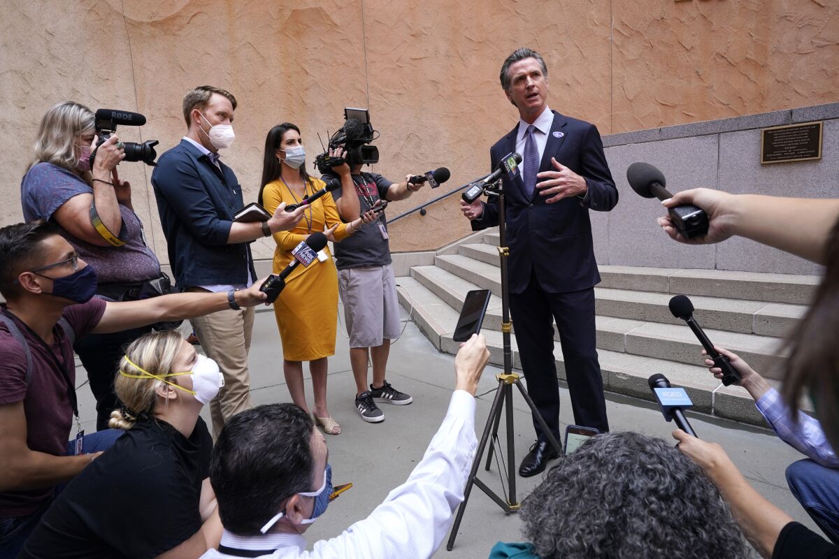 California Gov. Gavin Newsom responds to a question while meeting with reporters