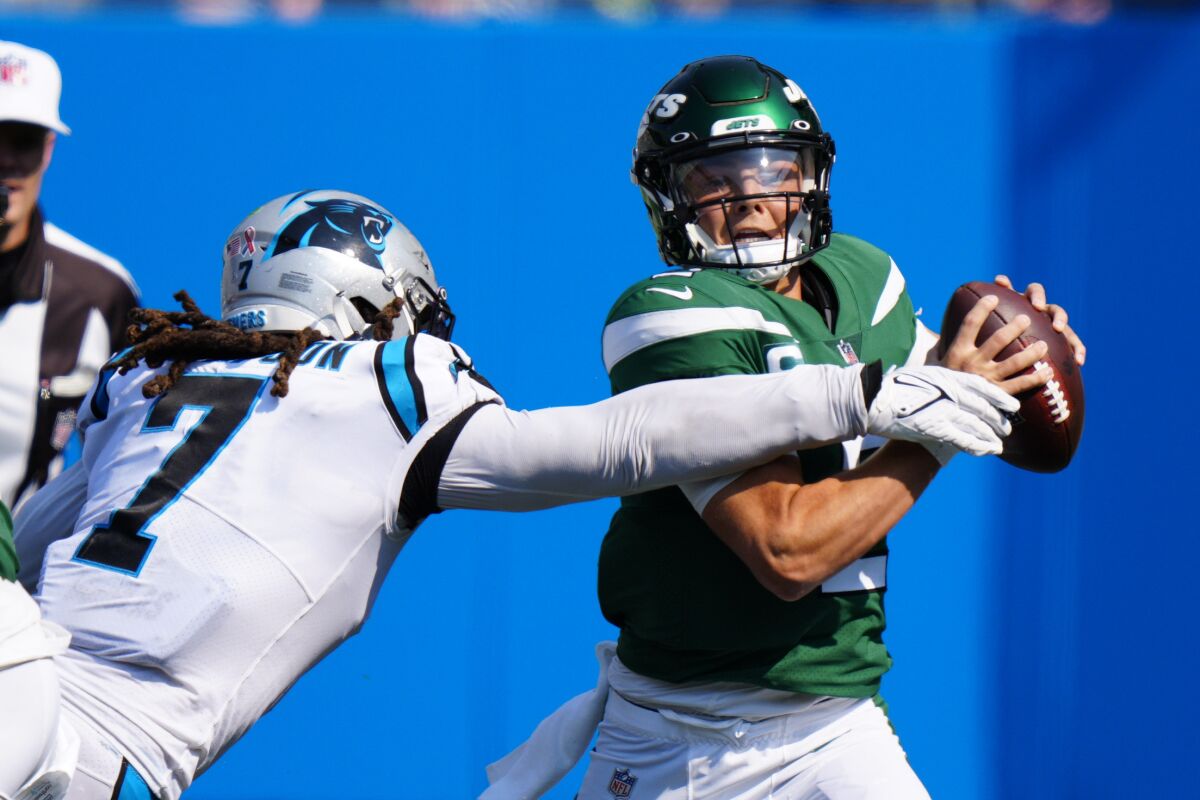 New York Jets quarterback Zach Wilson is sacked by Carolina Panthers outside linebacker Shaq Thompson during the second half of an NFL football game Sunday, Sept. 12, 2021, in Charlotte, N.C. (AP Photo/Jacob Kupferman)