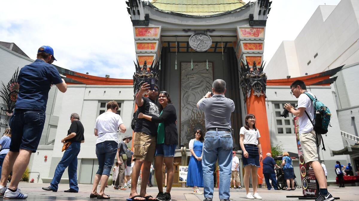 Tourists take photos in front of the TCL Chinese Theatre in Hollywood on May 2, 2017. Los Angeles plans to hire a consultant to try to boost tourism despite traffic gridlock, a lack of hotels and a stubborn homeless problem.