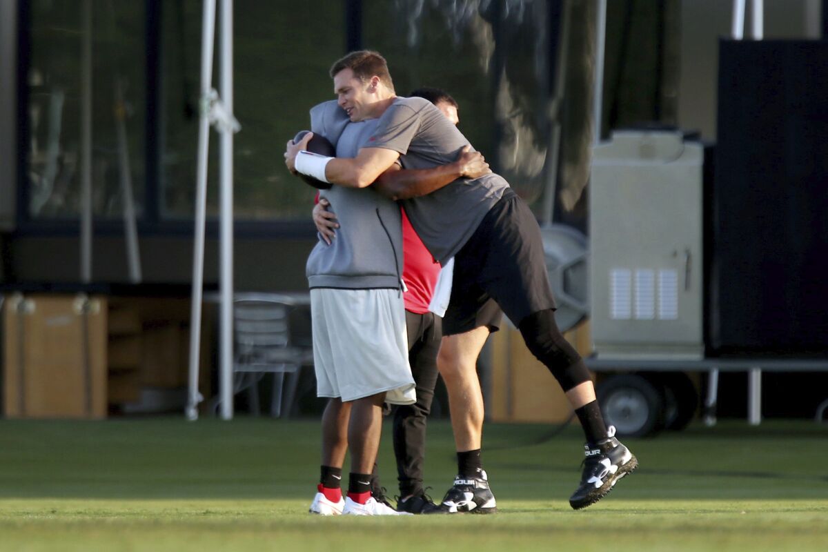 Tampa Bay Buccaneers running back LeSean McCoy, left, gets a hug from quarterback Tom Brady during NFL football training camp, Tuesday, Aug. 4, 2020, in Tampa. (Douglas R. Clifford/Tampa Bay Times via AP)