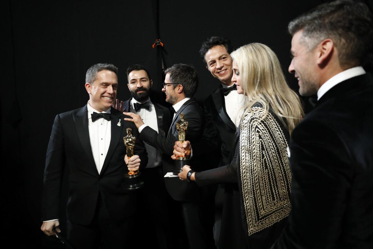 Team 'Coco': From left, Lee Unkrich, Adrian Molina, Gael Garcia Bernal, Benjamin Bratt and Darla K. Anderson backstage at the 90th Academy Awards.