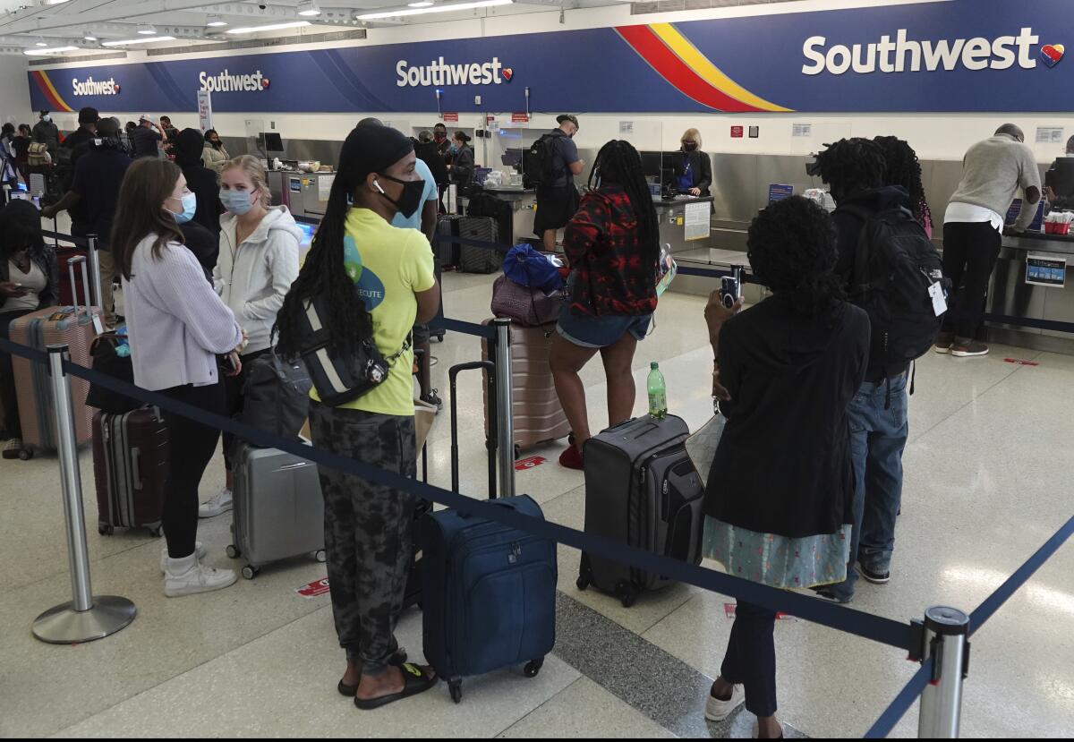 Passengers queue up at the ticketing counter for Southwest Airlines flights Sunday, Oct. 10, 2021, in Omaha, Neb. 