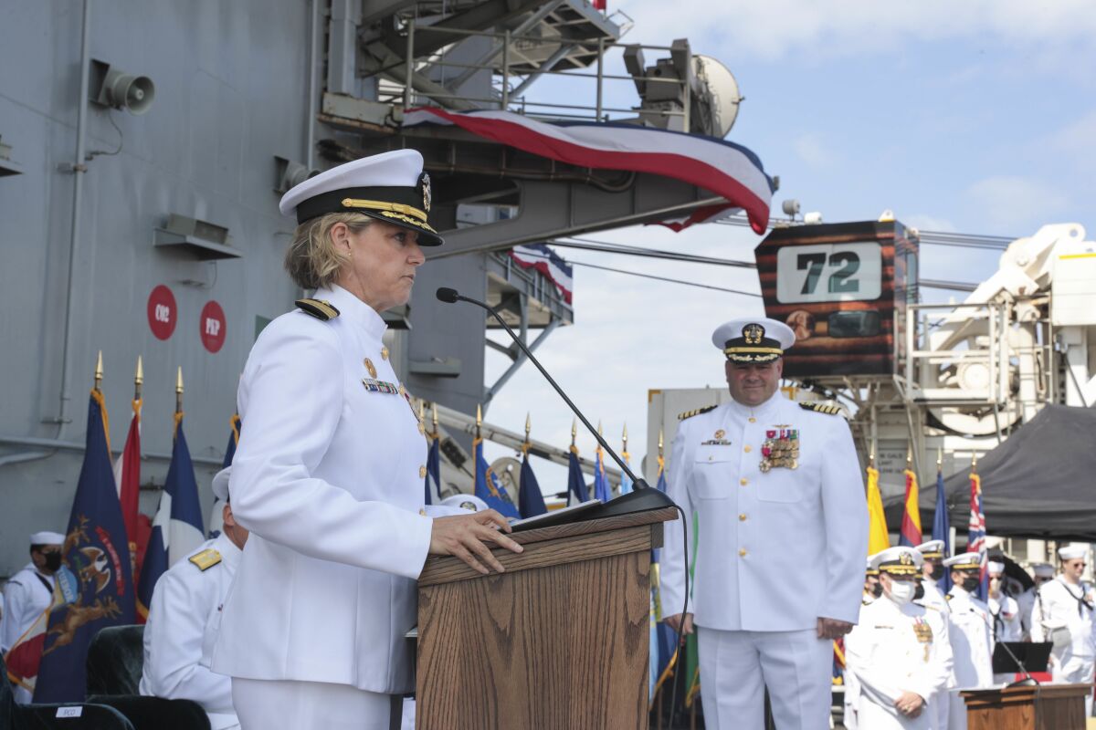 In this photo released by the U.S. Navy, Capt. Amy Bauernschmidt, left, incoming commanding officer of the aircraft carrier USS Abraham Lincoln (CVN 72), reads her orders during a change of command ceremony held on the flight deck in San Diego, Calif., on Aug. 19, 2021. Capt. Walt "Sarge" Slaughter, right, successfully completed his 26 month tour as commanding officer during which Abraham Lincoln completed a 10-month combat deployment, the largest carrier work package ever completed in San Diego, and returned to sea in preparation for an upcoming deployment amidst the COVID-19 pandemic. Slaughter was relieved by Capt. Amy Bauernschmidt. The USS Abraham Lincoln deployed Monday, Jan. 3, 2022, from San Diego under the command of Capt. Amy Bauernschmidt, the first woman to lead a nuclear carrier in U.S. Navy history. (Mass Communication Spc. 3rd Class Jeremiah Bartelt/U.S. Navy via AP)
