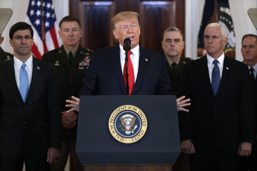 President Donald Trump addresses the nation from the White House on the ballistic missile strike that Iran launched against Iraqi air bases housing U.S. troops, Wednesday, Jan. 8, 2020, in Washington, as Vice President Mike Pence and others looks on. (AP Photo/ Evan Vucci)